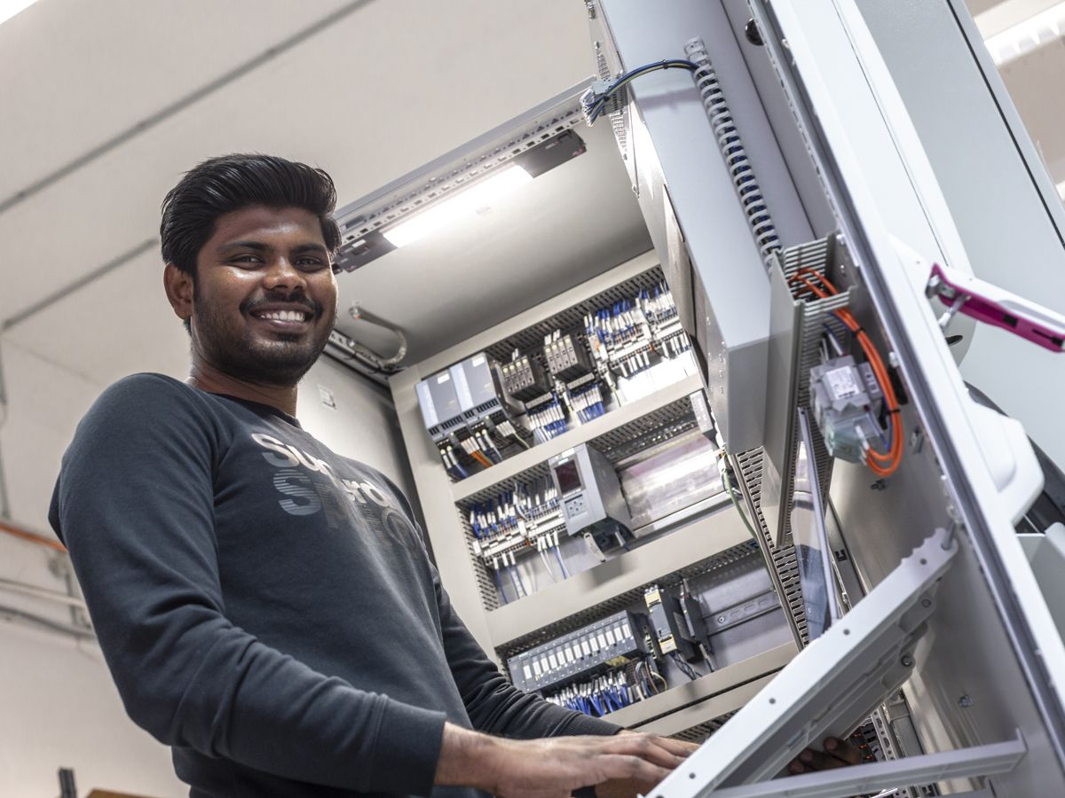 Employee at the open control cabinet during training