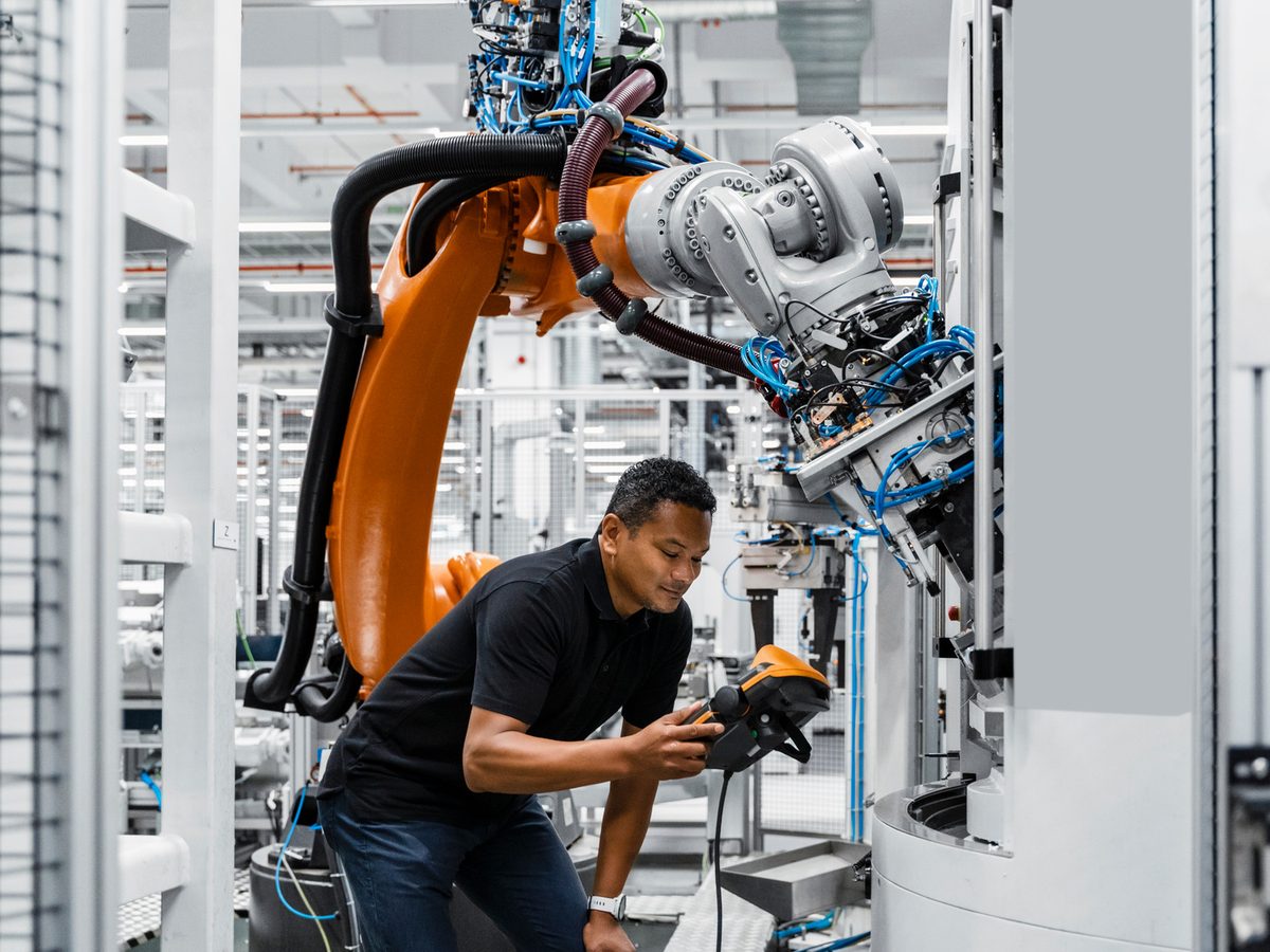 Technician with teach pendant at the robot during fault analysis